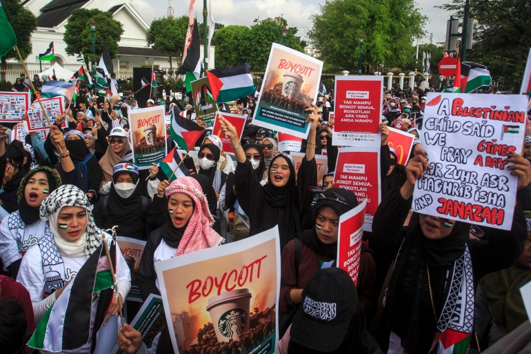 Demonstrators hold placards calling for the boycott of pro-Israel products and companies during a protest to show their solidarity with the Palestinian people in Yogyakarta on November 11, 2023. - Thousands of civilians, both Palestinians and Israelis, have died since October 7, 2023, after Palestinian Hamas militants based in the Gaza Strip entered southern Israel in an unprecedented attack triggering a war declared by Israel on Hamas with retaliatory bombings on Gaza. (Photo by DEVI RAHMAN / AFP)